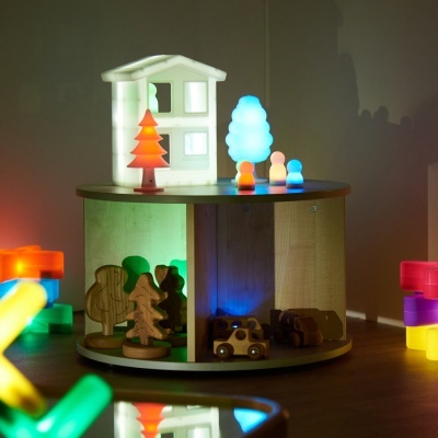 Expositor redondo em madeira com luzes coloridas e brinquedos luminosos