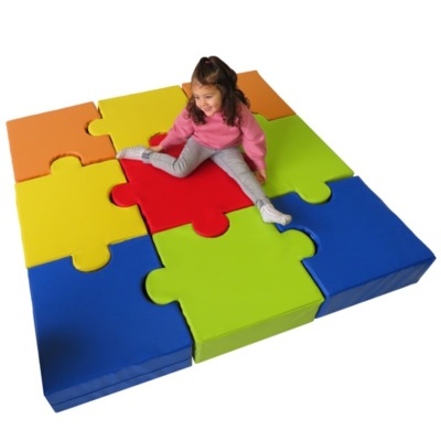 Tapete colorido em forma de puzzle com criança sentada no centro