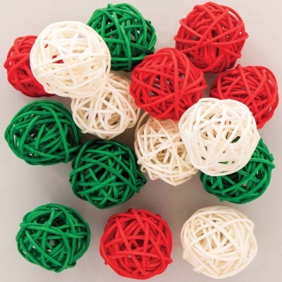 Bolas decorativas entrelaçadas em verde, vermelho e branco sobre superfície clara