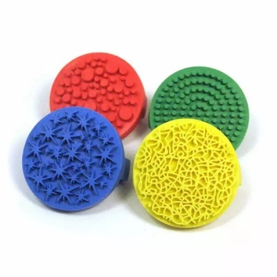 Quatro carimbos redondos coloridos com padrões texturizados distintos em fundo branco