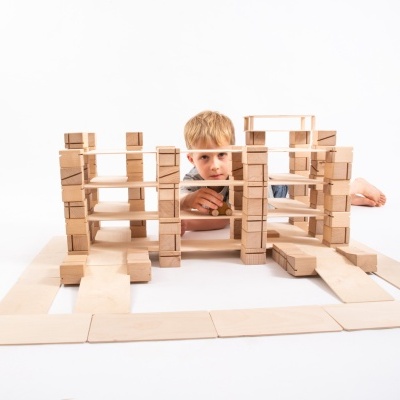 Menino a brincar com blocos de madeira para construir estruturas