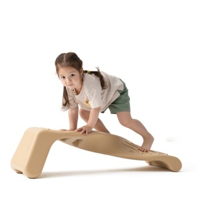 Criança a usar brinquedo infantil curvado de plástico bege com fundo branco