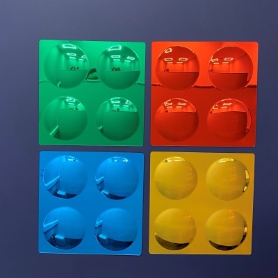 Peças quadradas de plástico colorido com cavidades circulares, em verde, vermelho, azul e amarelo.