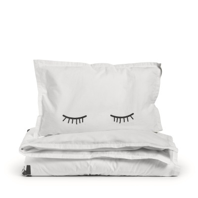 Conjunto de almofada e edredão brancos com design de olhos fechados