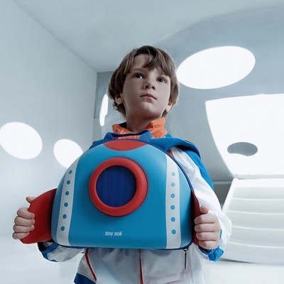Mochila infantil azul em forma de foguetão com detalhes vermelhos e brancos