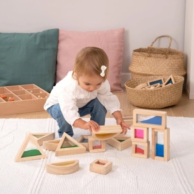 Criança a brincar com blocos de madeira coloridos em sala acolhedora