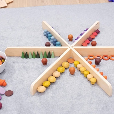 Jogo de madeira colorido com peças organizadas em estrutura em estrela sobre tapete cinza