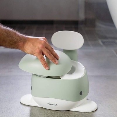 Penico infantil verde claro e branco com encosto, em chão de azulejos cinzentos