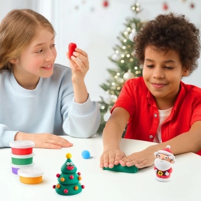 Crianças a brincar com massinha e figuras natalícias de massinha à mesa