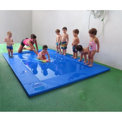 Piscina pequena azul para crianças num espaço interior com chão verde