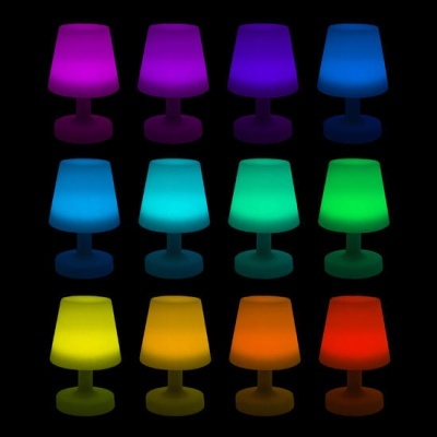 Doze candeeiros de mesa iluminados em várias cores sobre fundo preto