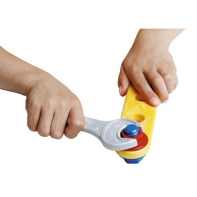 Mãos de criança usando chave inglesa de plástico para apertar peça amarela com parafuso azul e vermelho