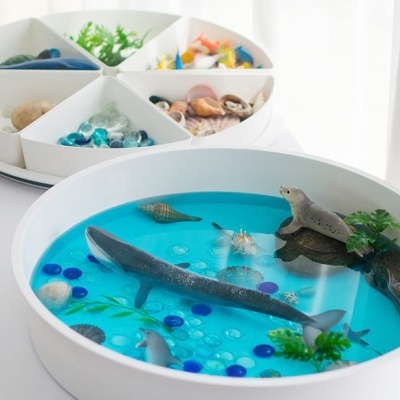 Bandejas redondas com água artificial azul e miniaturas de vida marinha