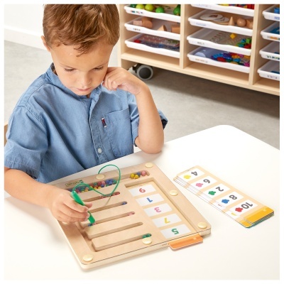 Criança a brincar com brinquedo educativo de madeira com contas coloridas e cartões de números