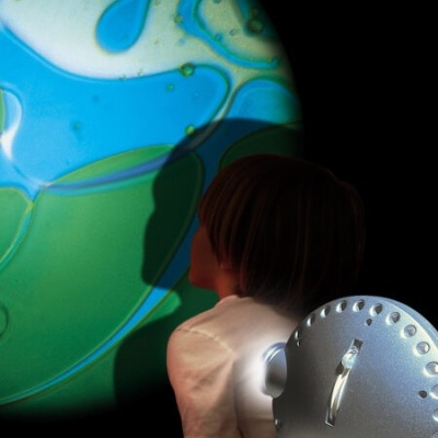 Projetor metálico exibindo imagem colorida abstrata para criança