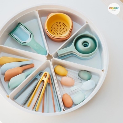 Conjunto colorido de utensílios de cozinha em silicone num prato branco dividido