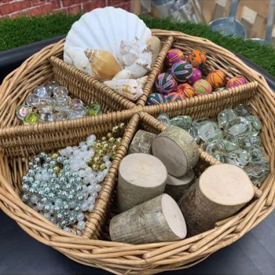 Cesto de verga com contas, bolas de vidro, madeira, conchas e bolas coloridas