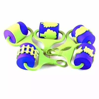 Cinco rolos de pintura em espuma azul e amarelo com padrões e duas pegas verdes sobre fundo branco