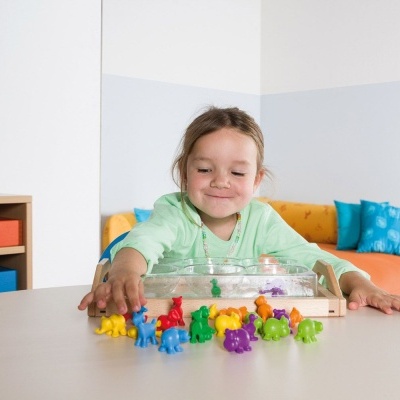 Brinquedo com figuras de animais coloridos e criança sorridente em ambiente interior