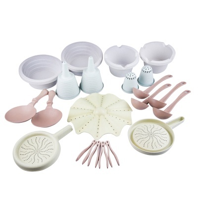 Conjunto de utensílios de cozinha em plástico rosa e branco sobre fundo branco