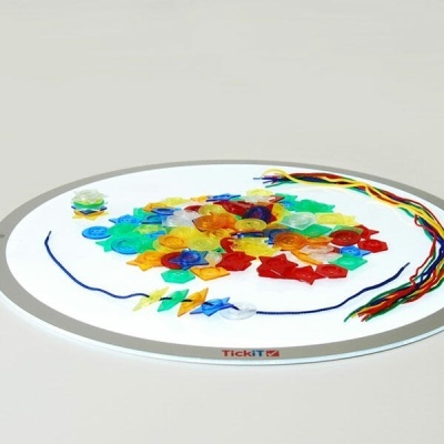 Tabuleiro com botões coloridos e cordões para atividades manuais