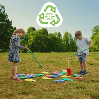 Crianças a jogar jogo de pesca com peixes coloridos no campo