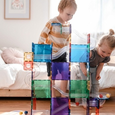 Brinquedo de construção translúcido colorido com crianças a brincar em quarto