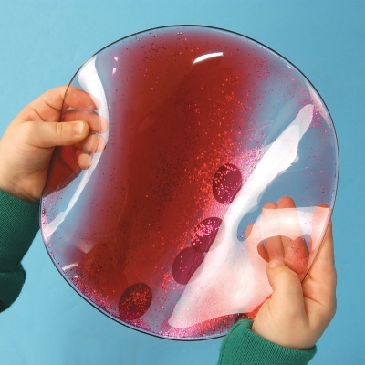 Prato de vidro transparente com manchas vermelhas segurado por duas mãos