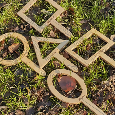moldes de madeira para desenho em várias formas com alça no chão de relva e folhas secas