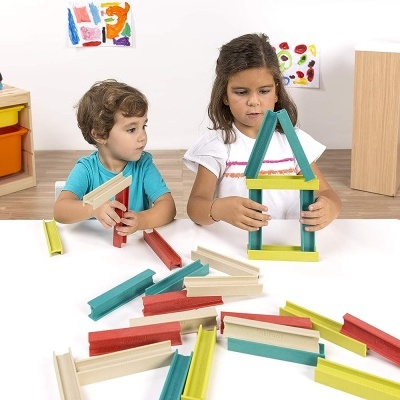 Crianças a brincar com blocos de construção de madeira coloridos numa mesa