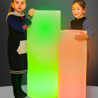 Dois candeeiros cilíndricos iluminados em verde e laranja segurados por crianças