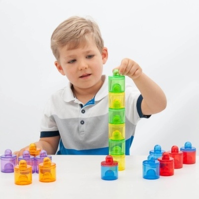 Menino a jogar com blocos de construir coloridos em superfície branca