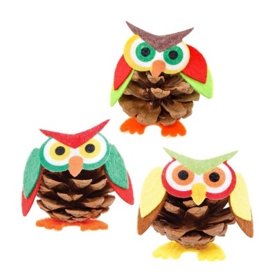 Três corujas feitas de pinhas e feltro colorido.