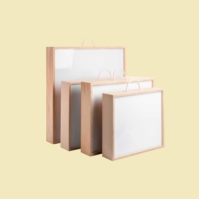 Conjunto de quatro quadros brancos com molduras de madeira clara e alças