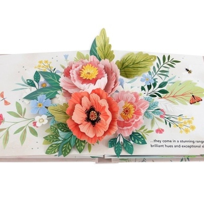 Livro pop-up aberto com flores coloridas e texto