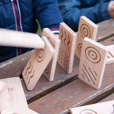 Peças de madeira retangulares com padrões gravados em relevo sobre banco de madeira