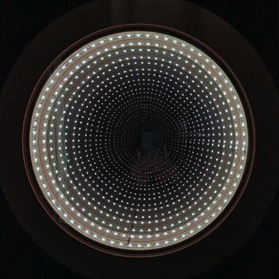 Espelho circular com luzes LED formando padrão infinito
