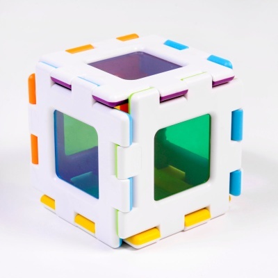 Cubo de brinquedo plástico branco com janelas coloridas translúcidas.