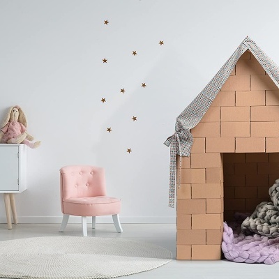 Casa de brincar de blocos de espuma em sala minimalista com cadeira rosa e móvel branco