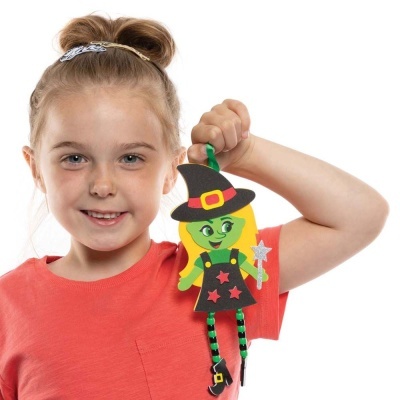 Menina a segurar boneco de bruxa de EVA colorido com chapéu e varinha