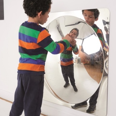 Criança vista de costas em frente a espelho convexo quadrado com moldura