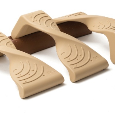 Três suportes plásticos bege com textura ondulada sobre fundo branco.