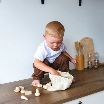 Criança a brincar com brinquedos de madeira num balcão de cozinha