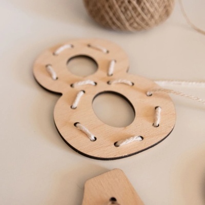 Números de madeira clara com fio branco entrançado.