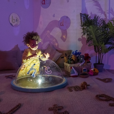 Criança a brincar com luzes e sombras em ambiente interior acolhedor