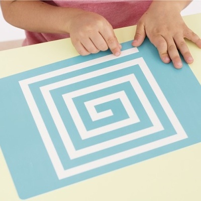 Folha azul com padrão espiral branco e mãos de criança em cima