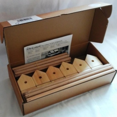 Kit de peças de madeira clara em caixa de cartão aberta com folheto branco