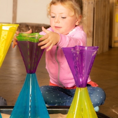 Criança a brincar com peças plásticas coloridas cónicas