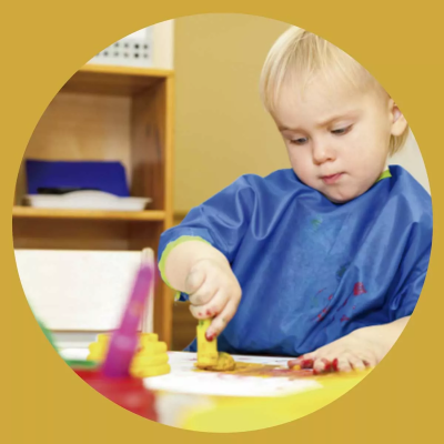 Criança a pintar com bata azul protetora