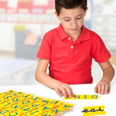 Camisola polo vermelha e letras de aprendizagem amarelas e azuis numa mesa branca